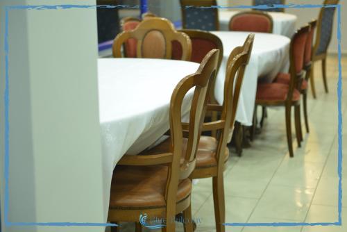 una fila de mesas y sillas en un restaurante en Blue Balcony Hotel en Golem