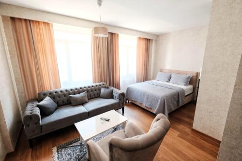 a living room with a bed and a couch at SABİHA GOKCEN İSTANBUL HOUSES Airport in Istanbul