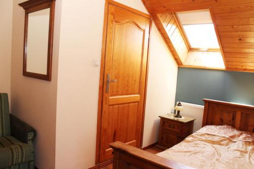 Schlafzimmer mit einem Bett und einer Holztür in der Unterkunft Willa Górskie Retro in Wisła