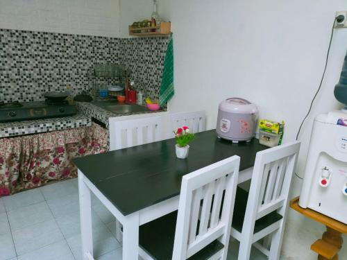 a kitchen with a table and two white chairs at Shifana homestay syariah in Yogyakarta