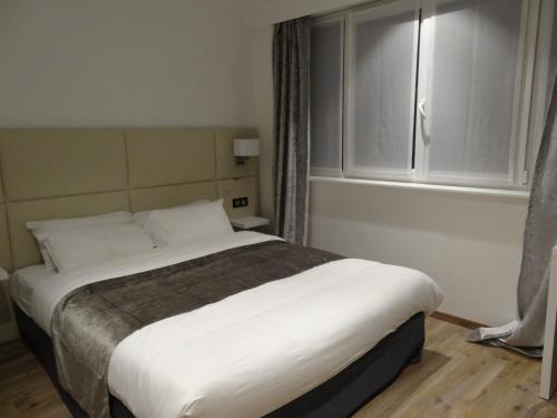 Ένα ή περισσότερα κρεβάτια σε δωμάτιο στο Hôtel de la Paix