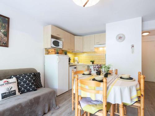 une cuisine avec une table et un réfrigérateur blanc dans l'établissement Appartement 4 pers à Saint-Lary village, quartier thermal, proche télécabine, parking privé - FR-1-296-374, à Saint-Lary-Soulan