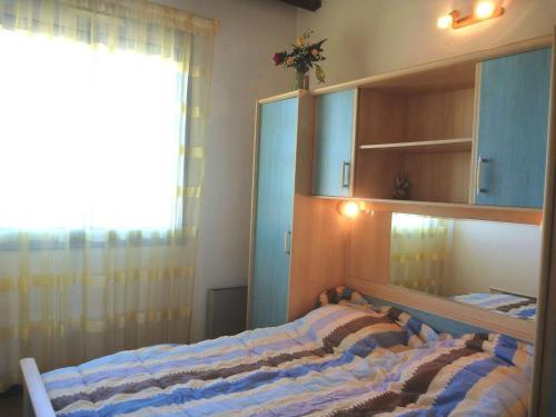 - une chambre avec un lit, une fenêtre et des armoires dans l'établissement Appartement 4 pers avec vue mer proche plage, animaux et parking inclus - FR-1-387-85, à Marseillan