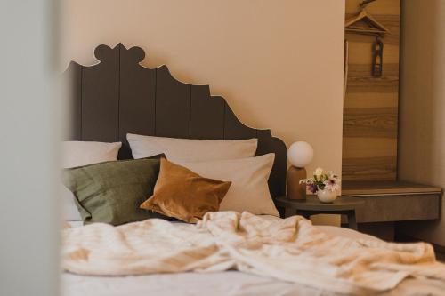 a bedroom with a bed with a wooden headboard and pillows at Hotel Stadthaus in Erlangen