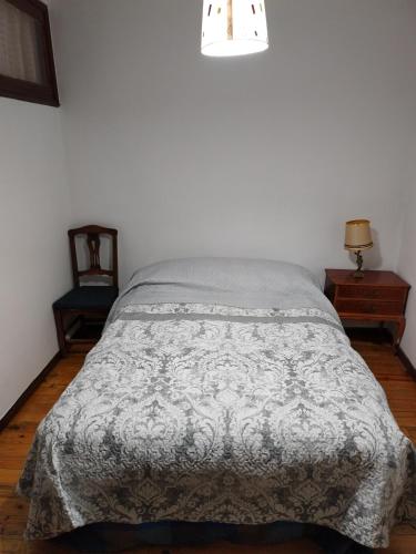 - une chambre avec un lit et une couverture grise dans l'établissement Berleo 1 Piso completo en pleno casco histórico., à Medina de Pomar