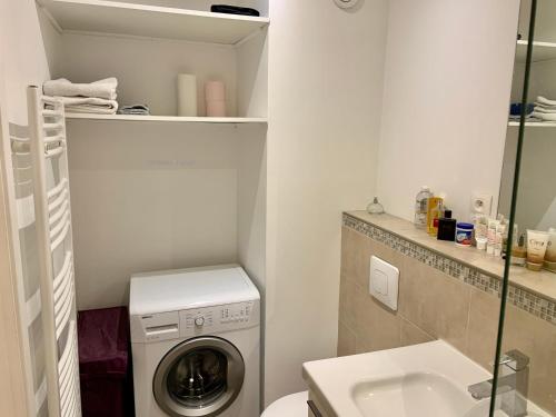 une salle de bain avec une machine à laver et un lavabo dans l'établissement Le Sainte Croix, beau T2 lumineux à 800 m de la gare St Jean, à Bordeaux