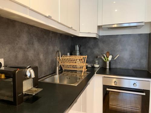 une cuisine avec un évier et une cuisinière dans l'établissement Le Sainte Croix, beau T2 lumineux à 800 m de la gare St Jean, à Bordeaux