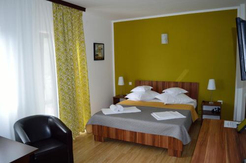 1 dormitorio con 1 cama con pared verde en Helen Vama Veche, en Vama Veche