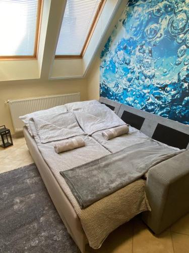 łóżko w pokoju z obrazem na ścianie w obiekcie Buborék Apartman w Hajduszoboszlo