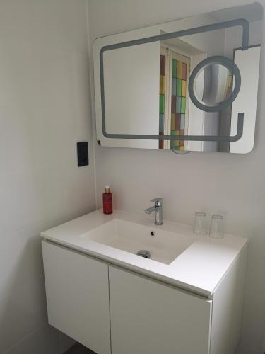 a bathroom with a white sink and a mirror at L'ARTiste in Lessines