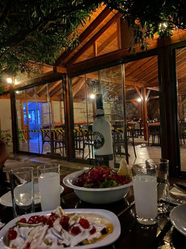 a table with a plate of food and a bottle of wine at Woodline Hotel in Kemer