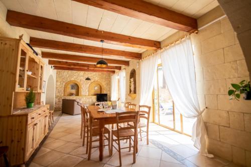 a kitchen and dining room with a table and chairs at Blossom Farmhouses in Għasri
