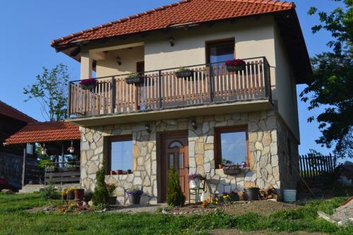 a small stone house with a balcony on top at Zlatibor Cottages in Zlatibor