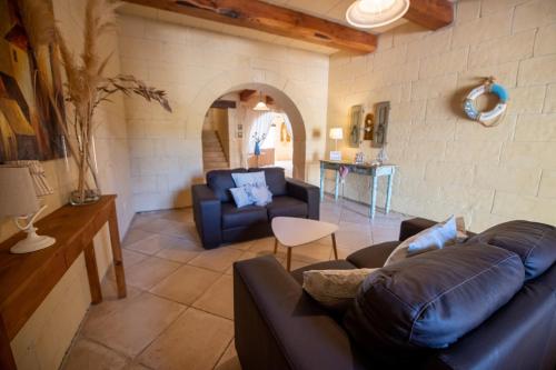 a living room with a couch and a table at Blossom Farmhouses in Għasri