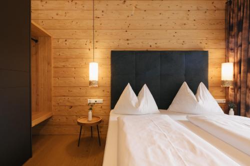 a bedroom with a bed with a black headboard and white pillows at Chalet Village by Apart4you in Ramsau am Dachstein