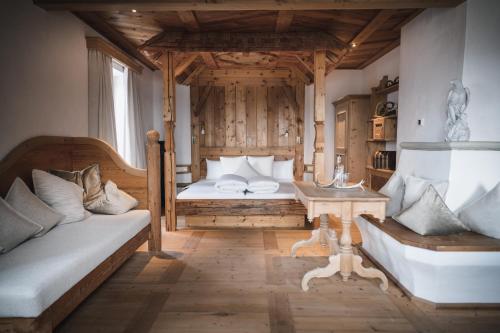 1 dormitorio con cama, sofá y mesa en Boutiquehotel Blaue Burg Falkenstein en Pfronten
