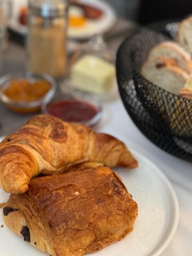 een bord met croissants en ander gebak op een tafel bij L'Oiseau Bleu PEACOCK in Roubia