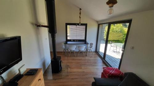 a living room with a television and a table with chairs at Chata Lesní in Klíny