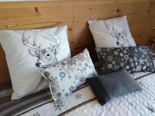 - 2 têtes de cerf sur les oreillers d'un lit dans l'établissement Cosy appartement La Bresse centre ville, à La Bresse