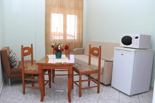 a living room with a table and chairs and a microwave at Isabela Apartments in Sarandë