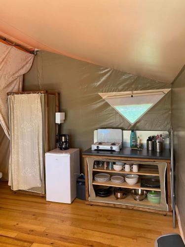 - une cuisine dans une tente avec un réfrigérateur dans l'établissement Camping 46 Rainettes, à Goujounac