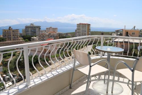 a balcony with a table and chairs and a view of the city at Isabela Apartments in Sarandë