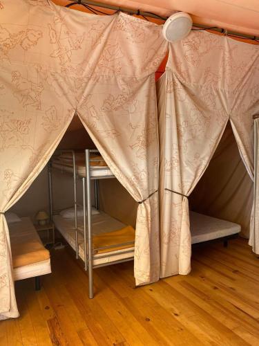 - une chambre avec 2 lits superposés dans une tente dans l'établissement Camping 46 Rainettes, à Goujounac