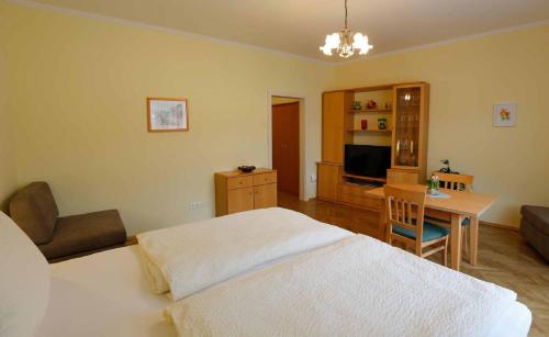 a bedroom with a bed and a table and a desk at Gästehaus Huber in Weissenkirchen in der Wachau