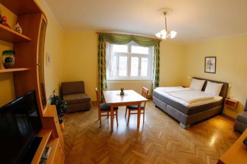 a bedroom with a bed and a table and a tv at Gästehaus Huber in Weissenkirchen in der Wachau