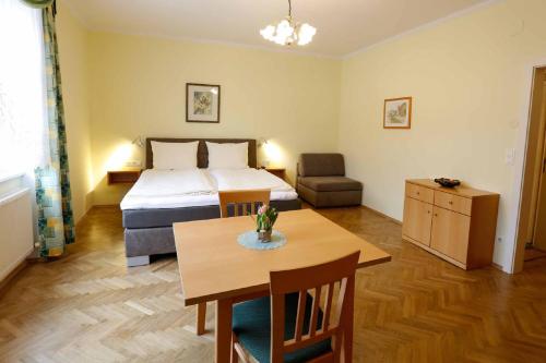 ein Hotelzimmer mit einem Bett, einem Tisch und einem Bett in der Unterkunft Gästehaus Huber in Weissenkirchen in der Wachau