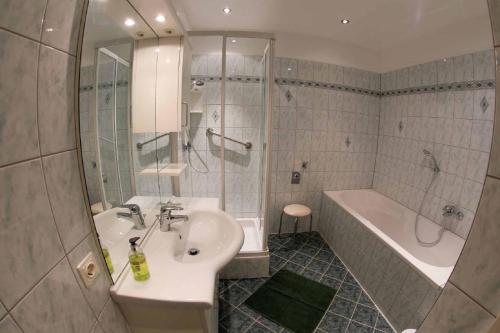 ein Badezimmer mit einem Waschbecken, einer Badewanne und einem Waschbecken in der Unterkunft Gästehaus Huber in Weissenkirchen in der Wachau
