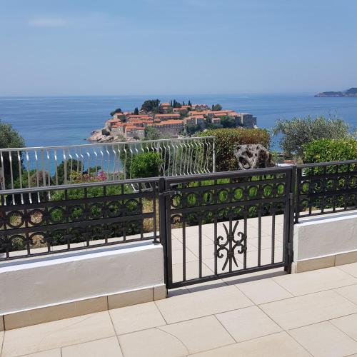 a black fence with a view of the ocean at Vila Horizont in Sveti Stefan