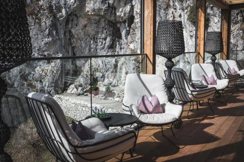 a group of chairs and tables on a deck at Boutiquehotel Blaue Burg Falkenstein in Pfronten