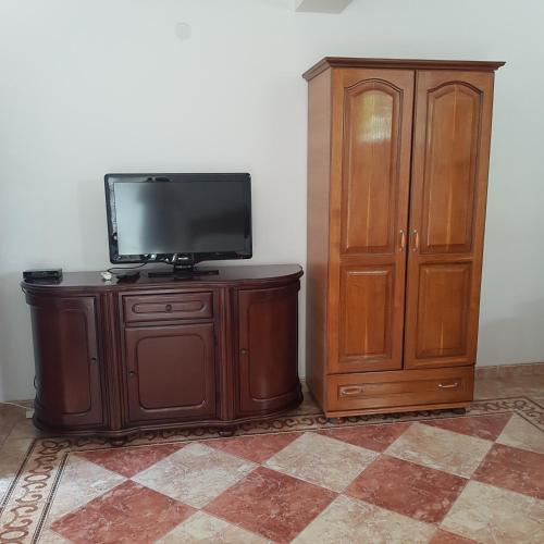 a wooden entertainment center with a television and a cabinet at Vila Horizont in Sveti Stefan