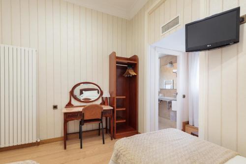 a bedroom with a desk and a mirror and a bed at Hostal Oliva in Barcelona