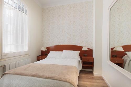 a bedroom with a large bed and two night stands at Hostal Oliva in Barcelona