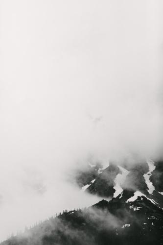 a black and white photo of a mountain with clouds at Chalet Village by Apart4you in Ramsau am Dachstein