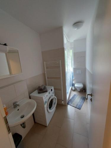 a bathroom with a washing machine and a sink at Ferienwohnung in Beelitz Heilstätten in Beelitz