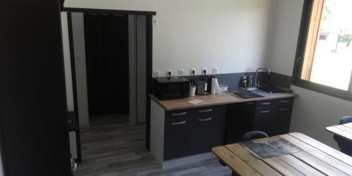 a kitchen with a counter and a table in a room at la chambre du clos Barriant in Séreilhac