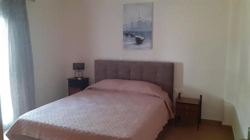 a bedroom with a bed and a picture on the wall at ILIANA.APARTMENTS in Kardamaina