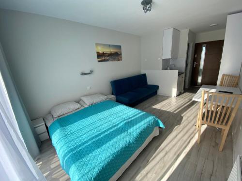 ビャウォグラにあるPokoje Gościnne Bosmanのベッドルーム(青いベッド1台、ソファ付)