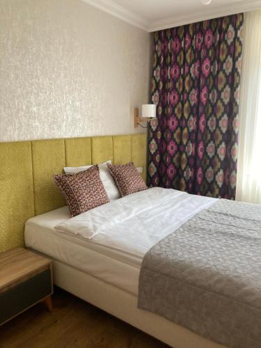 a bedroom with a bed and a window with a curtain at Willa Witkacy in Słupsk