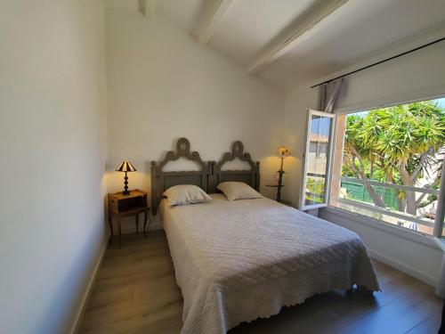 a bedroom with a bed and a large window at FREJUS Maison 3 chambres 100m2 Climatisee 6 Person in Fréjus