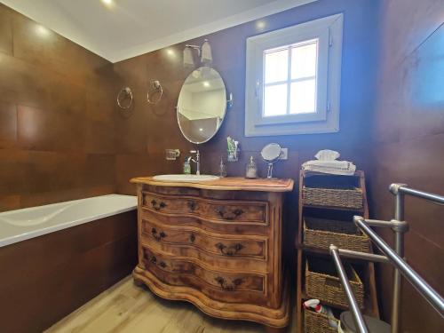 a bathroom with a wooden dresser with a sink and a mirror at FREJUS Maison 3 chambres 100m2 Climatisee 6 Person in Fréjus