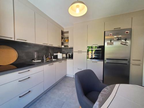  La cuisine est équipée de placards blancs et d'un réfrigérateur. dans l'établissement FREJUS Maison 3 chambres 100m2 Climatisee 6 Person, à Fréjus