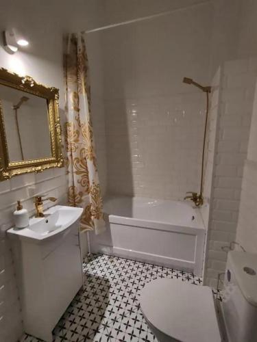 a bathroom with a white tub and a sink and a toilet at Park Rezydencja in Legnica