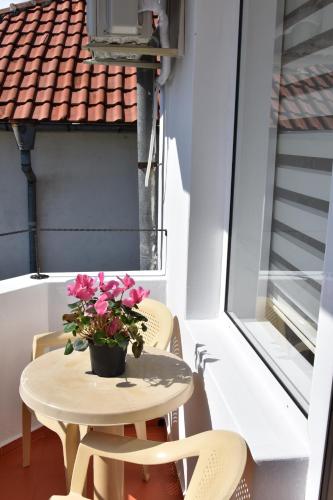 a small table with flowers on a balcony at Guest House DARIS-APHRODEYA Къща за Гости ДАРИС-АФРОДЕЯ in Sozopol