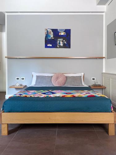 a bedroom with a large bed with a wooden frame at Alkimia Smart Rooms in Ferrara