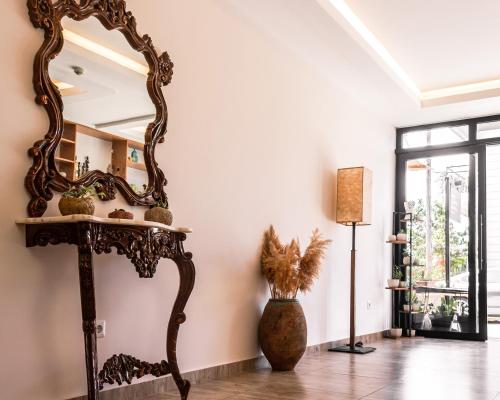 a mirror on a stand in a room with a vase at Kaş Old Town Hotel in Kaş