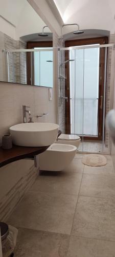 a bathroom with two sinks and a large mirror at Lithos house pt 1p e 2p in Monopoli
